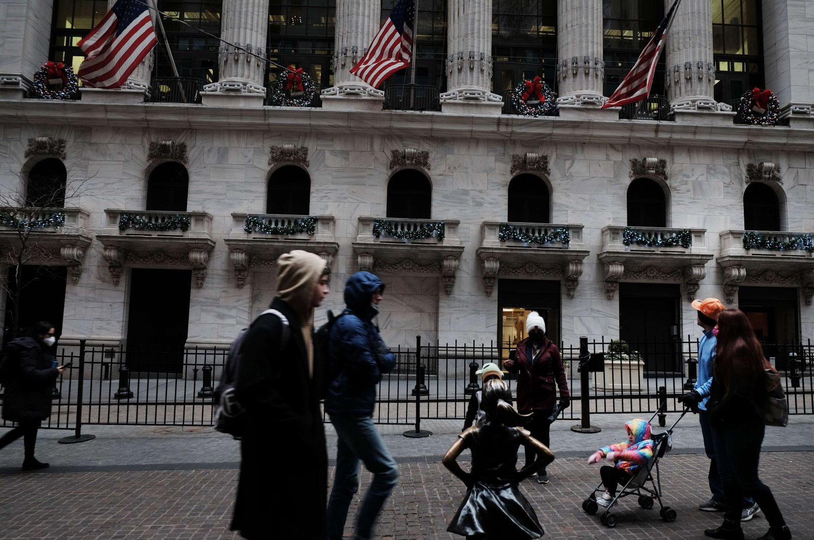 People walk by the New York Stock Exchange (NYSE) on the first day of trading in the new year, New York City, U.S., Jan. 3, 2022. (AFP Photo)