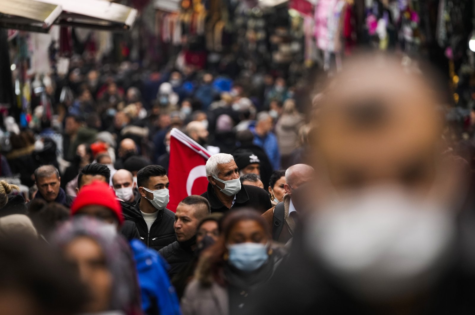 Pedestrians, some wearing protective face masks to prevent the spread of the COVID-19, walk in a street market, Istanbul, Turkey, Dec. 31, 2021. (AP Photo)