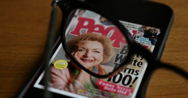 In this photo illustration produced Jan. 1, 2022, in Washington, D.C., a pair of glasses magnify the face of U.S. actress Betty White appearing on the cover of People Magazine. (AFP)