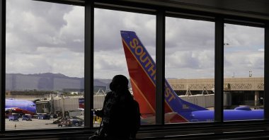 A passenger walks past a Southwest Airlines plane at Sky Harbor International Airport in Phoenix, U.S., March 26, 2021. (AP Photo)
