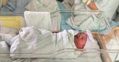 Aylin Trujillo, born at midnight on Jan. 1, 2022, lies in a bassinet while her twin brother Alfredo Trujillo, born at 11:45 p.m. on Dec. 31, 2021, is held, in Salinas, California, U.S., Jan. 1, 2022. (Natividad Medical Center/via Reuters)