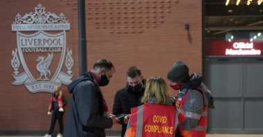 Stewards check the fans for COVID-19 documents at the entrance of Anfield stadium before a Premier League match against Newcastle United, Liverpool, England, Dec. 16, 2021. (AP Photo)