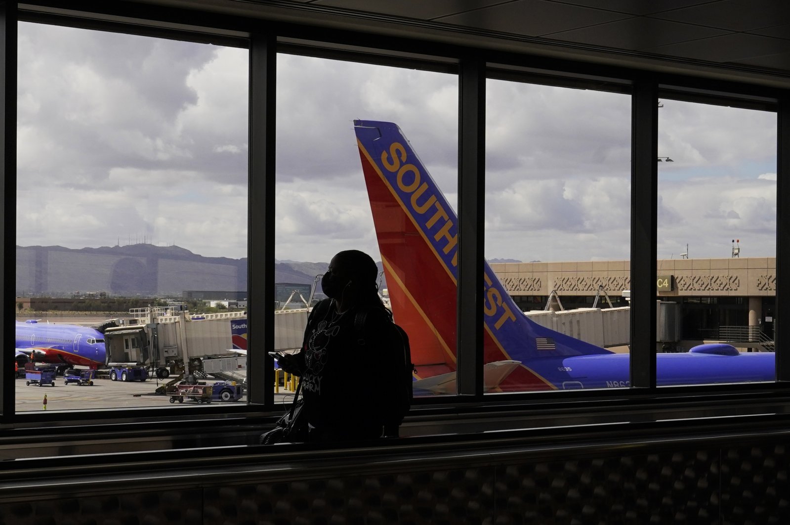 A passenger walks past a Southwest Airlines plane at Sky Harbor International Airport in Phoenix, U.S., March 26, 2021. (AP Photo)