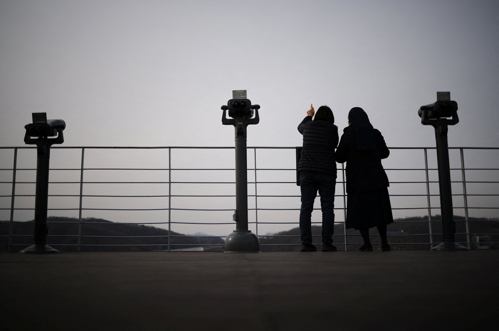 A woman and nun look toward the north, near the demilitarised zone which separates the two Koreas, in Paju, South Korea, Jan. 5, 2022. (Reuters Photo_