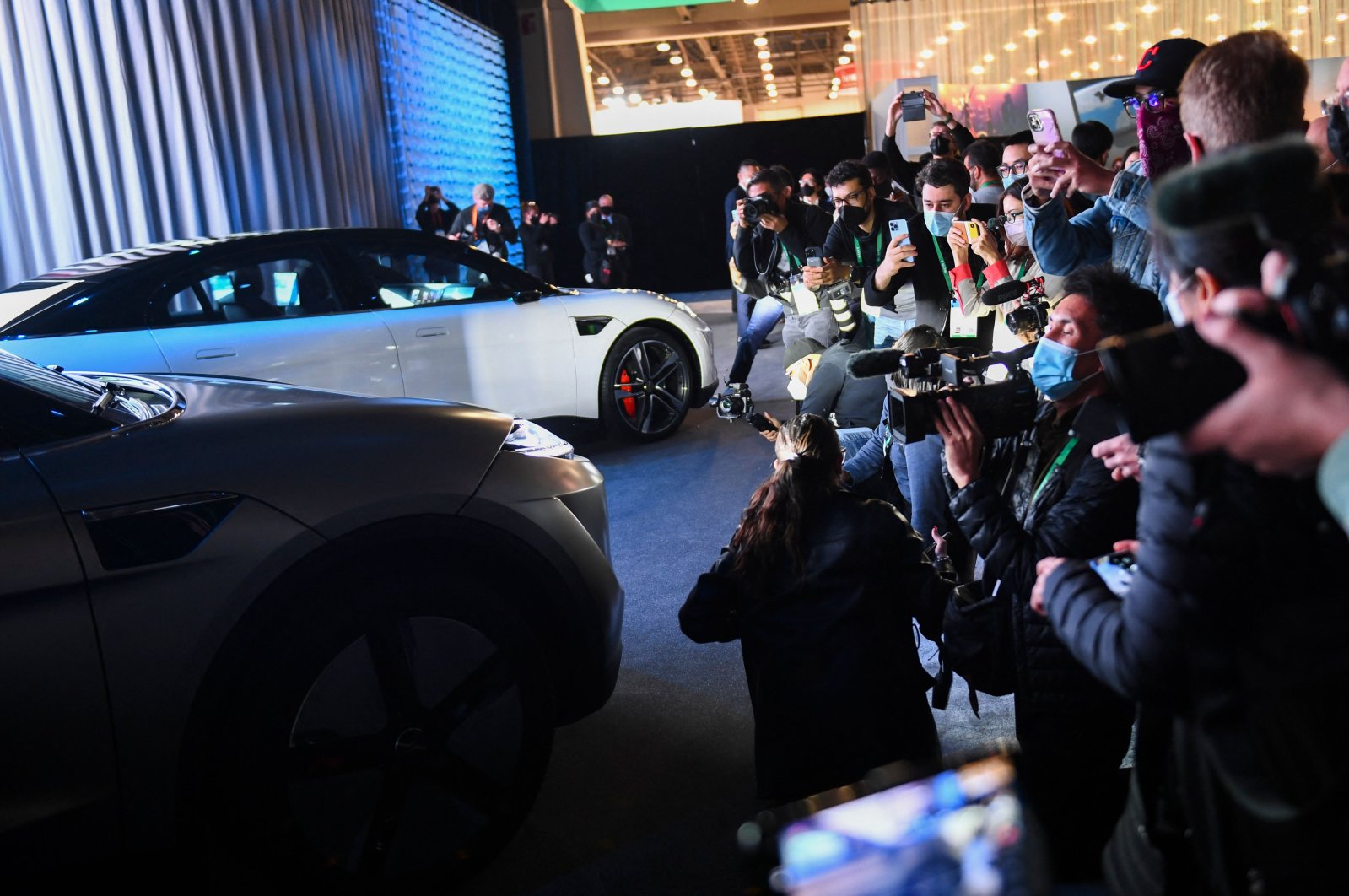 A crowd of attendees wear face masks as they photograph the Sony Vision-S SUV prototype electric vehicle after it is unveiled during the Sony press conference ahead of the Consumer Electronics Show (CES), Las Vegas, U.S., Jan. 4, 2022. (AFP Photo)