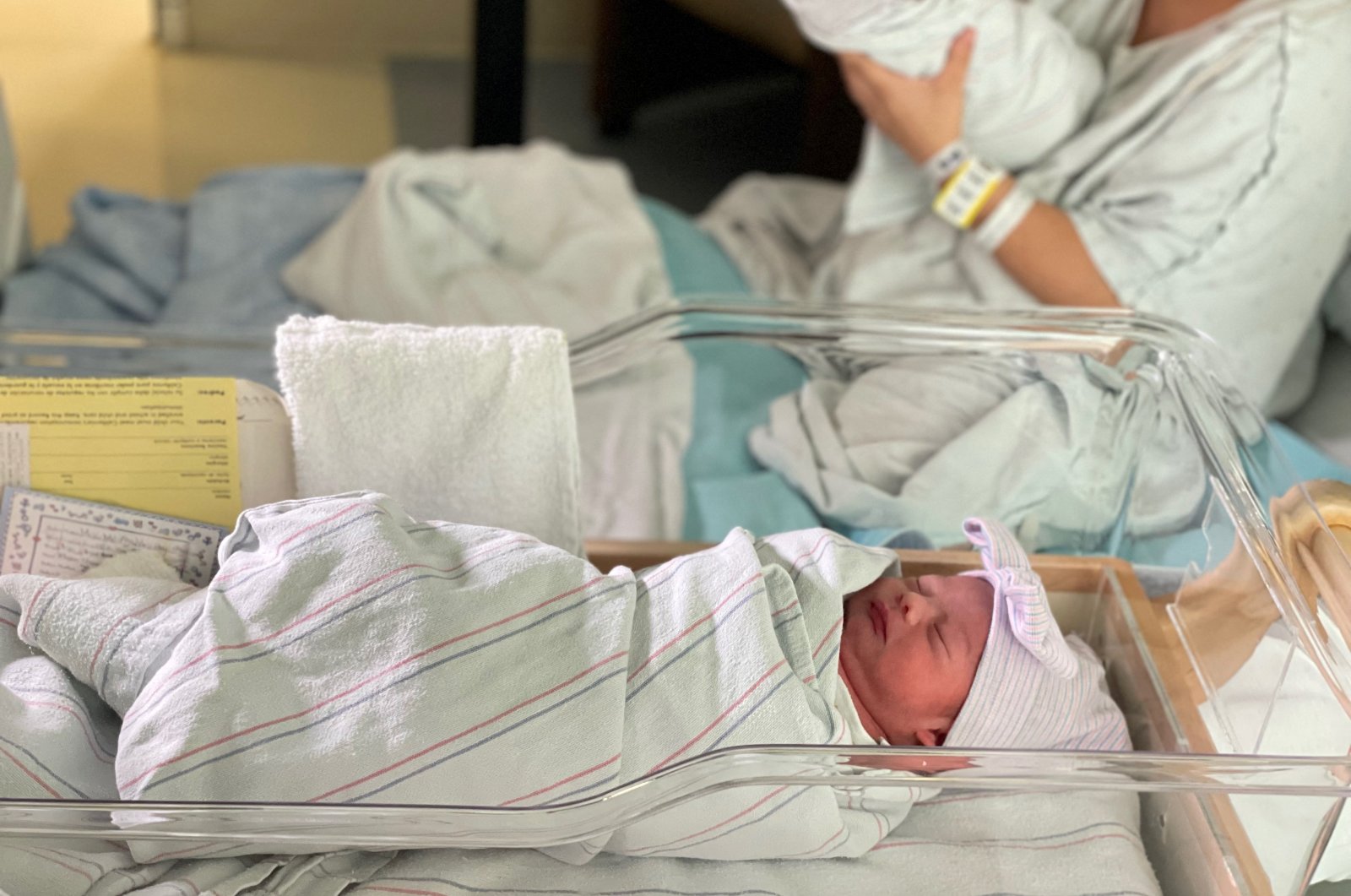 Aylin Trujillo, born at midnight on Jan. 1, 2022, lies in a bassinet while her twin brother Alfredo Trujillo, born at 11:45 p.m. on Dec. 31, 2021, is held, in Salinas, California, U.S., Jan. 1, 2022. (Natividad Medical Center/via Reuters)
