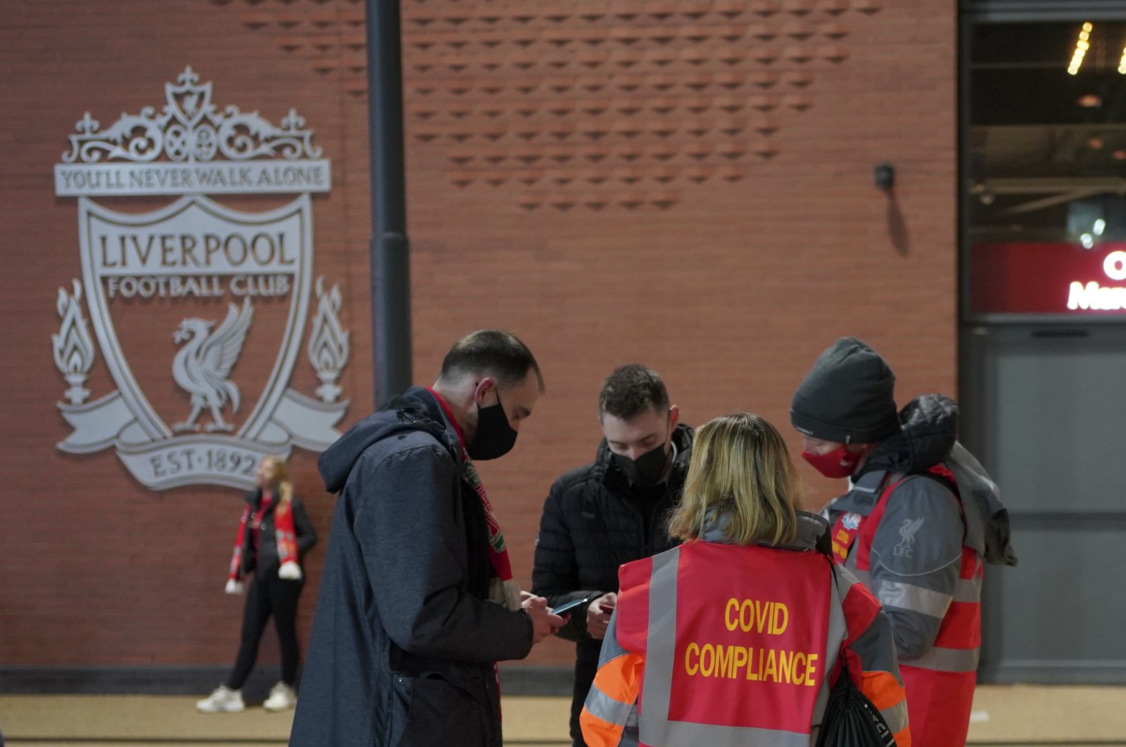 Stewards check the fans for COVID-19 documents at the entrance of Anfield stadium before a Premier League match against Newcastle United, Liverpool, England, Dec. 16, 2021. (AP Photo)