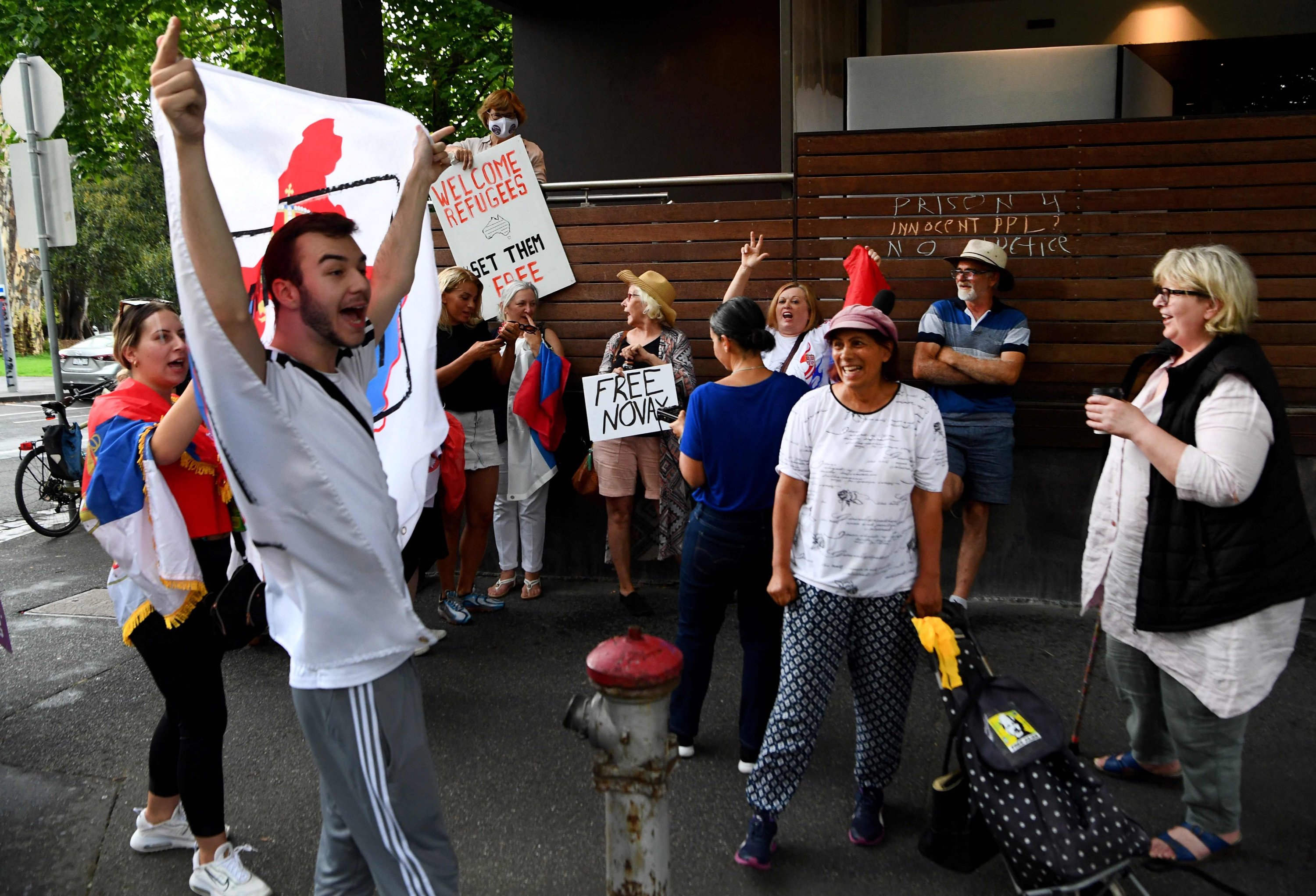Anggota komunitas Serbia setempat berkumpul di luar hotel tempat juara tenis Serbia Novak Djokovic dilaporkan menginap, Melbourne, Australia, 6 Januari 2022. (AFP Photo)