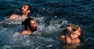 Orthodox faithful Galip Yavuz kisses the crucifix he retrieved, in Istanbul, Turkey, Jan. 6, 2022. (AFP PHOTO) 