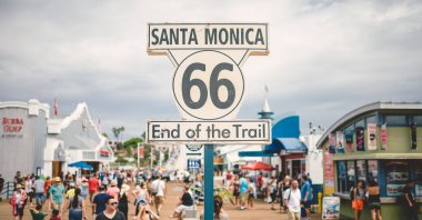 People walking by the famous Route 66 sign on Santa Monica Pier, Los Angeles, California, U.S. (Shutterstock Photo)