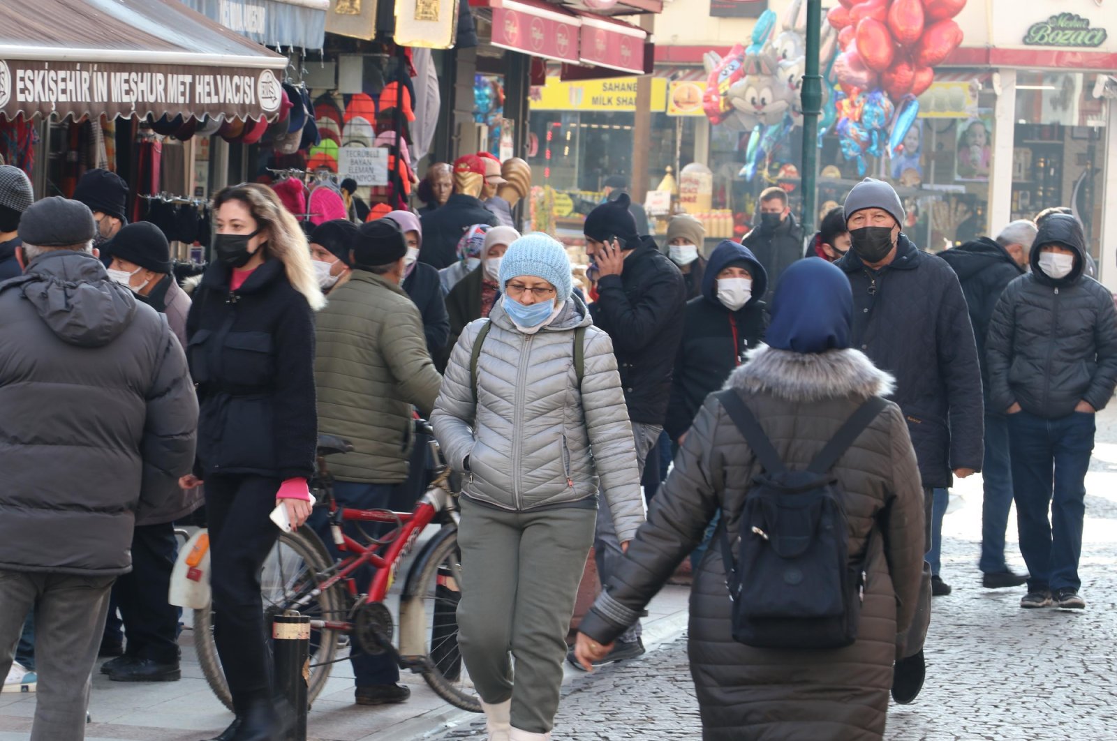 People wearing protective masks against COVID-19 walk on a street, in Eskişehir, central Turkey, Jan. 3, 2022. (DHA PHOTO) 