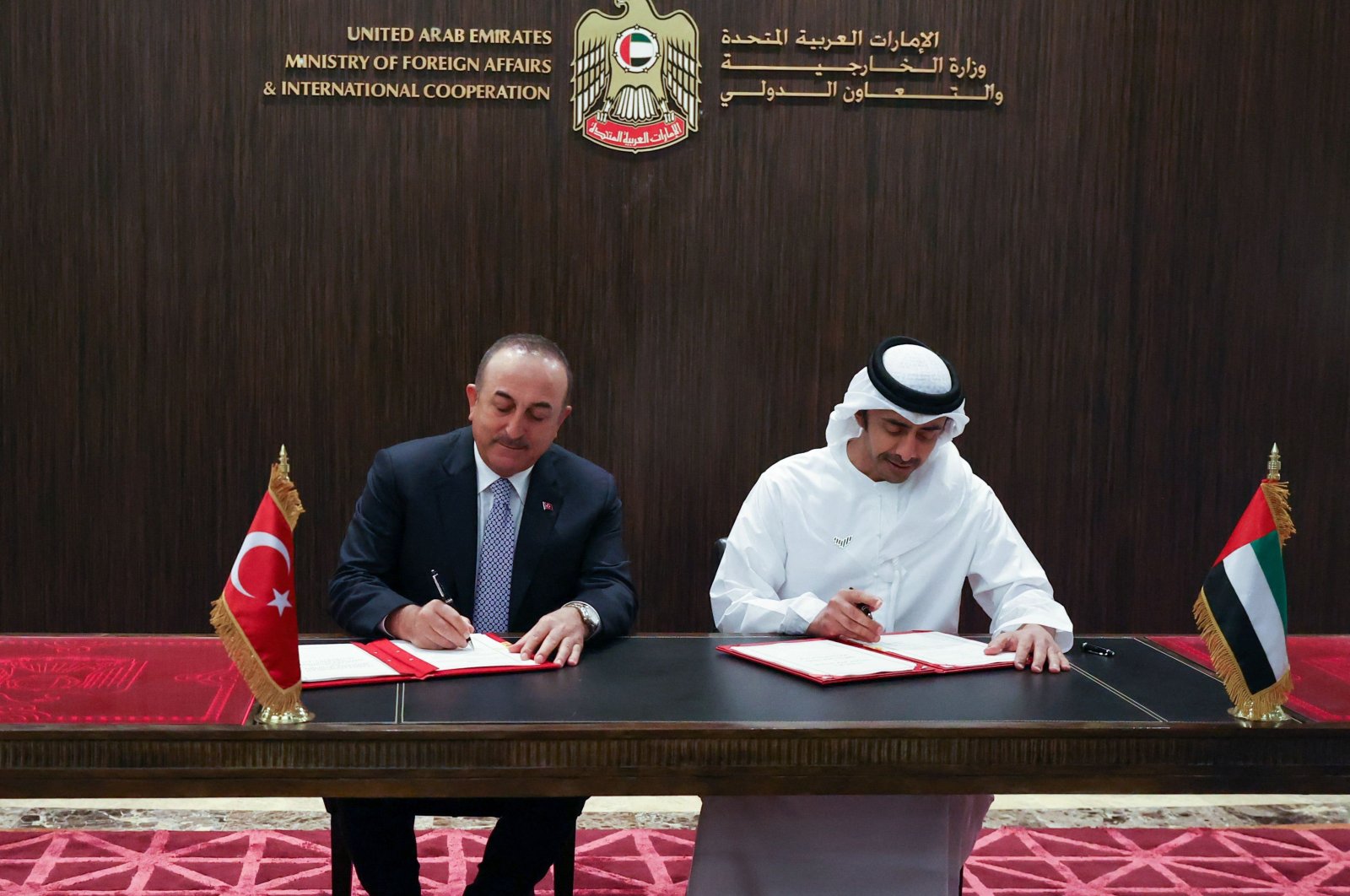 Foreign Minister Mevlüt Çavuşoğlu (L) and his UAE counterpart Sheikh Abdullah bin Zayed Al Nahyan sign a memorandum of understanding in Abu Dhabi, UAE, Dec. 15, 2021. (AFP Photo)
