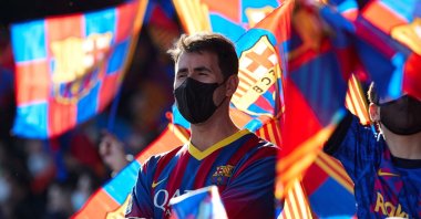 A Barcelona fan is surrounded by the club's flags during an open-door training session at the Camp Nou, Barcelona, Spain, Jan. 3, 2022. (EPA Photo)
