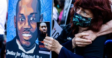 A woman holds portraits of Ahmaud Arbery and George Floyd during an event in remembrance of George Floyd in Minneapolis, Minnesota, U.S., May 23, 2021. (AFP Photo)