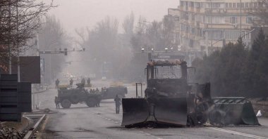 Service officials and their military vehicles block a street in central Almaty after violence erupted following protests over hike in fuel prices, Kazakhstan, Jan. 7, 2022, . (AFP Photo)