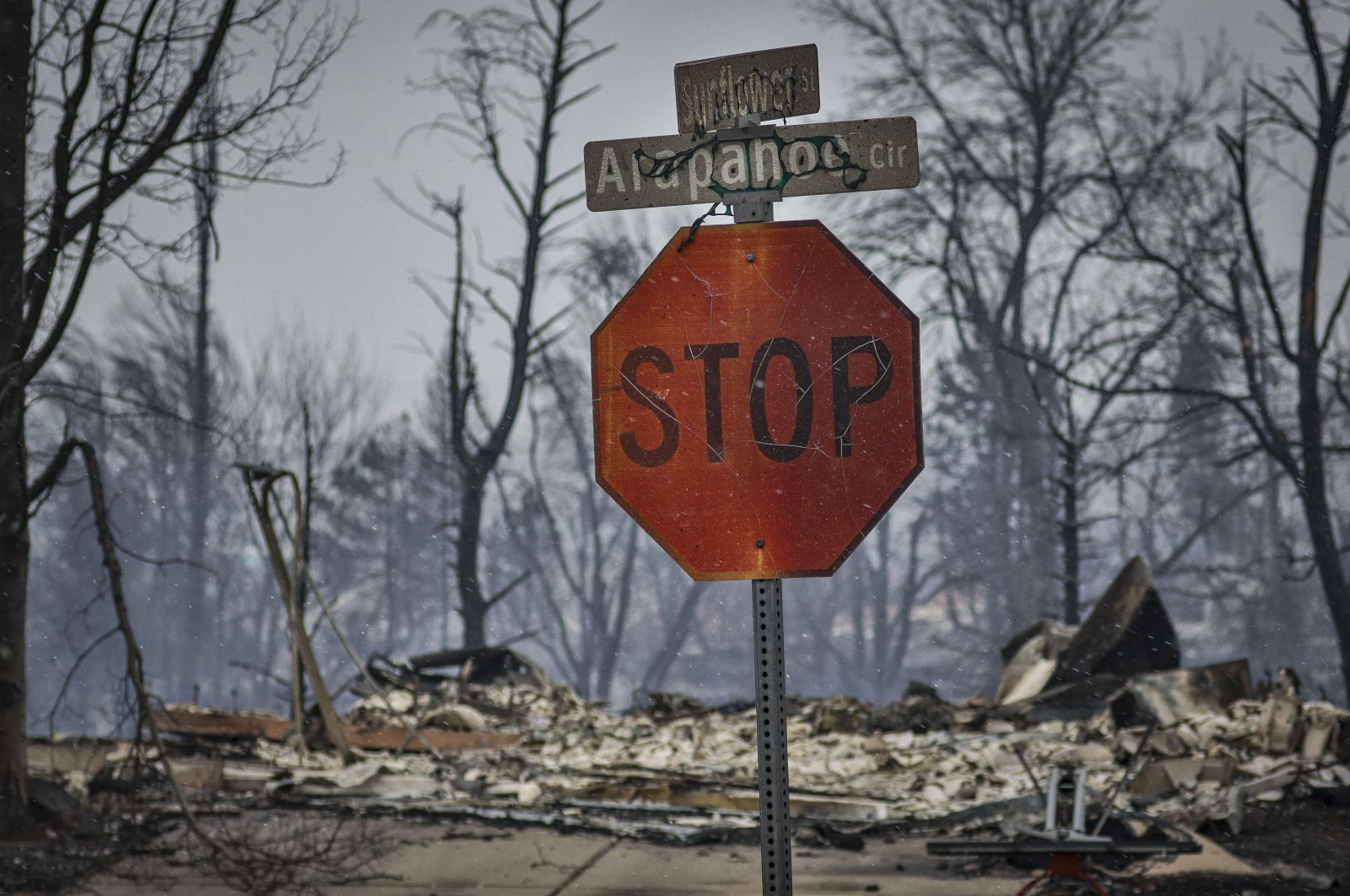 A stop sign and street signage peeled and cracking after intense heat from a wildfire in the aftermath of the Marshall Fire in Louisville, Colorado, on Dec. 31, 2021. (Getty Images/AFP Photo)