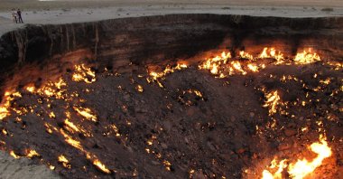 People visiting "The Gateway to Hell," a huge burning gas crater in the heart of the vast Karakum desert, Turkmenistan, June 11, 2014. (Photo by Igor SASIN / AFP)