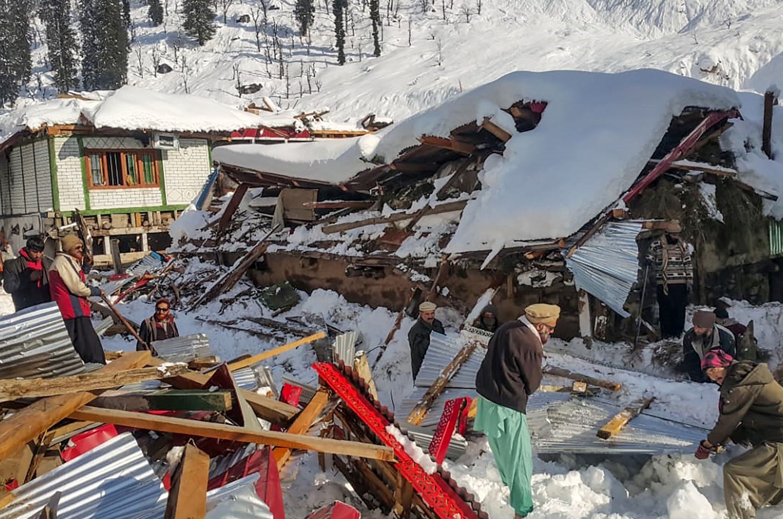Local residents remove debris of a collapsed house following heavy snowfall that triggered an avalanche in Neelum Valley, in Pakistan-administered Kashmir, Jan. 14, 2020. (AFP Photo)