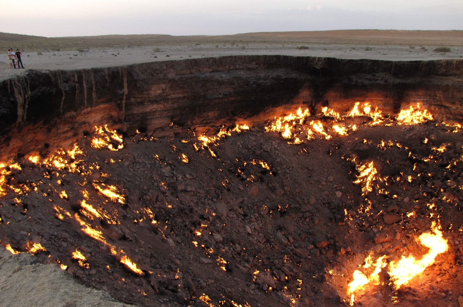 People visiting "The Gateway to Hell," a huge burning gas crater in the heart of the vast Karakum desert, Turkmenistan, June 11, 2014. (Photo by Igor SASIN / AFP)