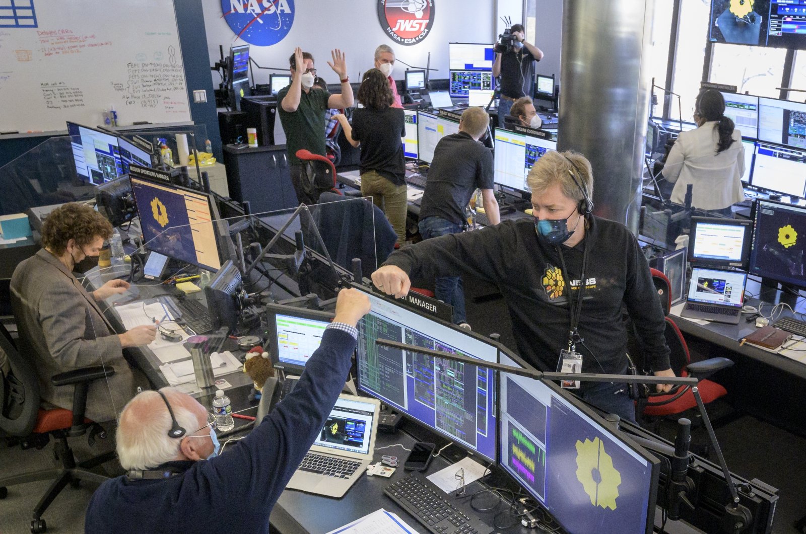 Engineering teams celebrate at the Space Telescope Science Institute as the second primary mirror wing of NASA&#039;s James Webb Space Telescope unfolds, before beginning the process of latching the mirror wing into place, in Baltimore, U.S., Jan. 8, 2022. (AP Photo)