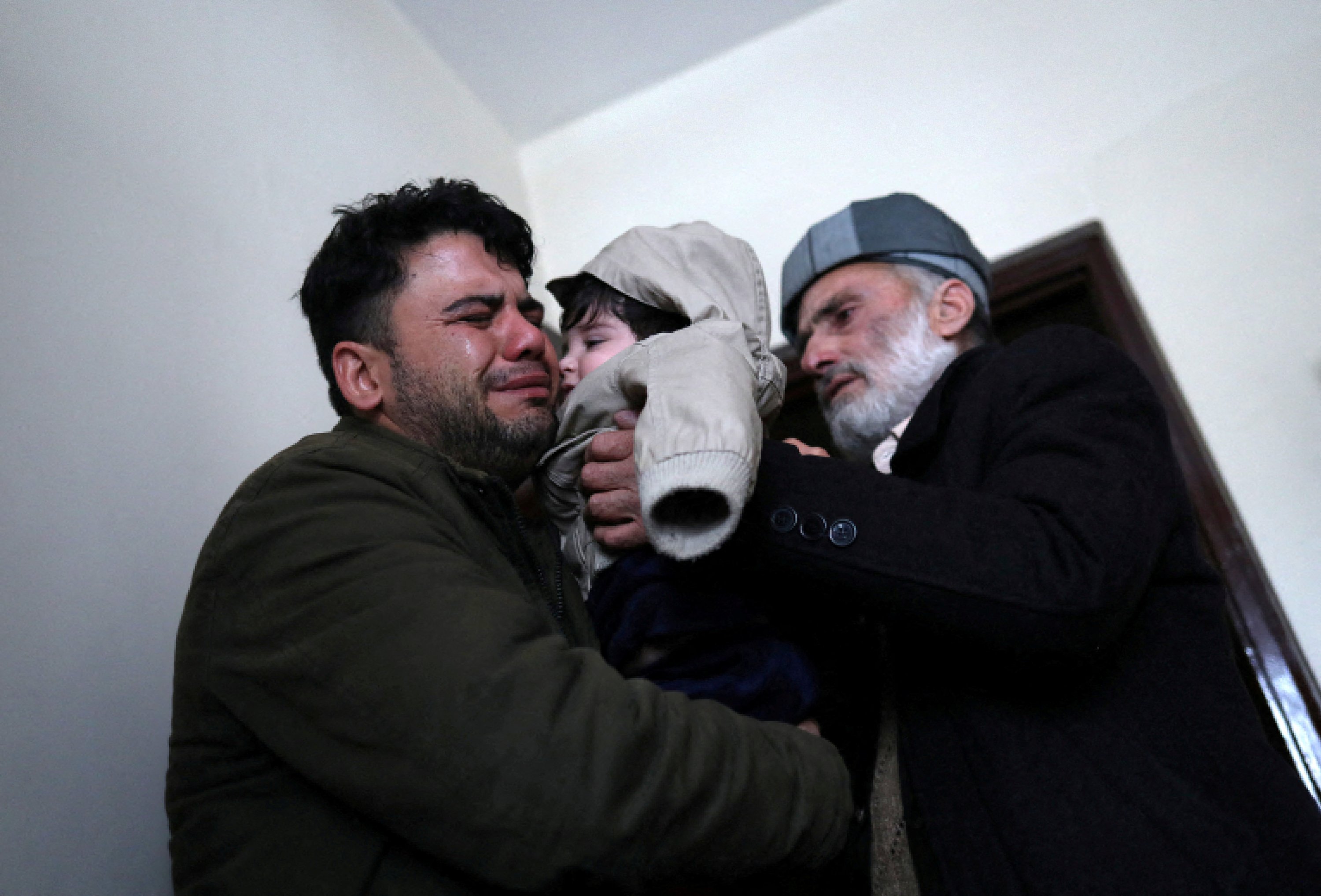 Hamid Safi, a 29-year-old taxi driver who had found baby Sohail Ahmadi in the airport, cries as he hands over Sohail to his grandfather Mohammad Qasem Razawi in Kabul, Afghanistan, Jan. 8, 2022. (Reuters Photo)