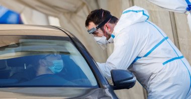 A man is tested for COVID-19 by a medical worker at a drive-in testing site during the coronavirus disease (COVID-19) pandemic, in Zagreb, Croatia, Jan. 7, 2022. (Reuters Photo)