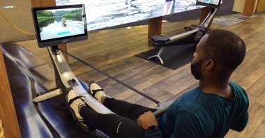 Aquil Abdullah, an employee of the Hydrow rowing fitness company, demonstrates a rowing machine at the CES technology show in Las Vegas, U.S., Jan. 7, 2022. (AFP Photo)