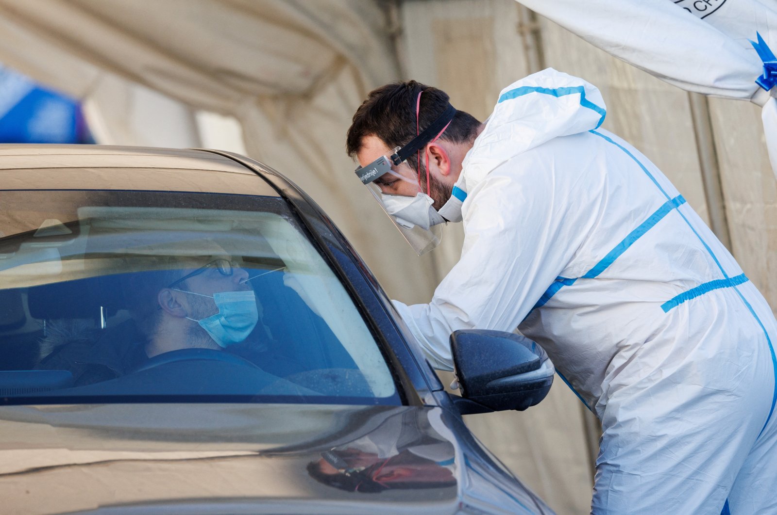 A man is tested for COVID-19 by a medical worker at a drive-in testing site during the coronavirus disease (COVID-19) pandemic, in Zagreb, Croatia, Jan. 7, 2022. (Reuters Photo)