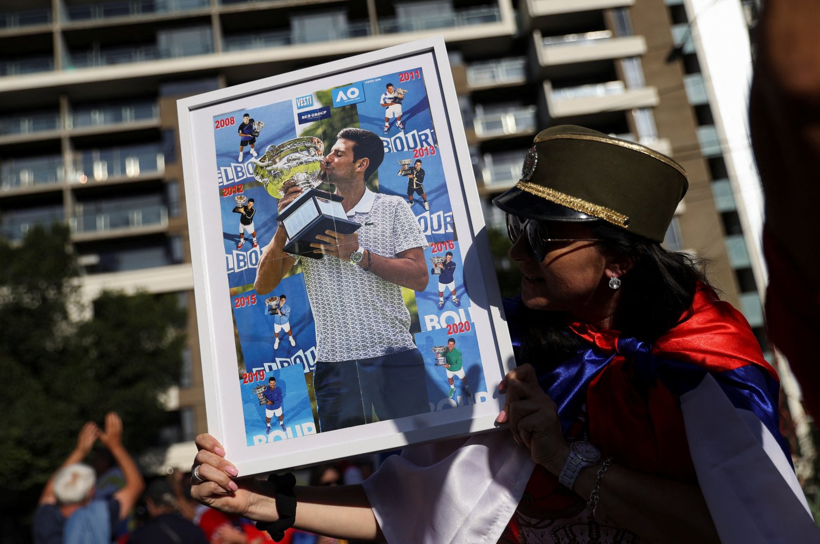 A supporter of Serbian tennis player Novak Djokovic holds his photo during a rally outside the Park Hotel, where the star athlete is believed to be held, Melbourne, Australia, Jan. 9, 2022. (Reuters Photo)