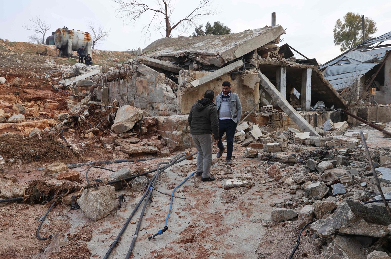 People assess the damage at the Arshani water station after it was reportedly hit by a Russian airstrike, in the village of the same name, northeast of the city of Idlib, Syria, Jan. 2, 2022. (AFP)