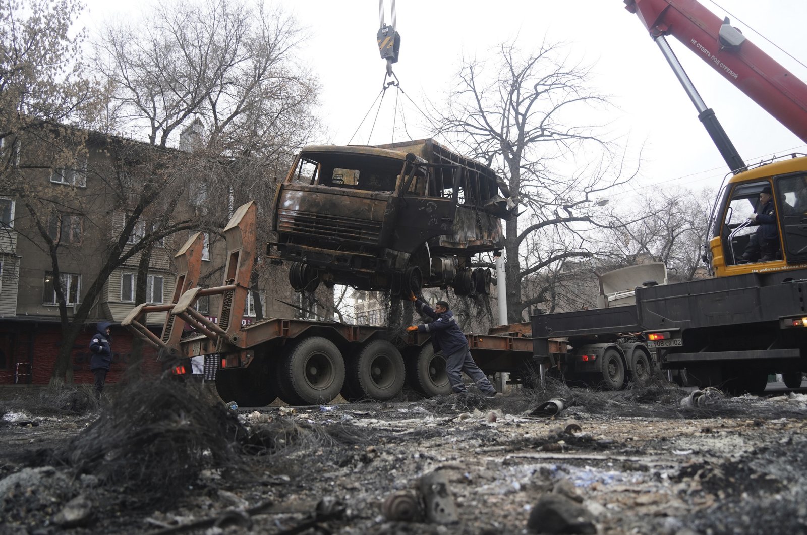 A crane loads a military truck burned during clashes onto the platform in Almaty, Kazakhstan, Jan. 9, 2022. (AP Photo)