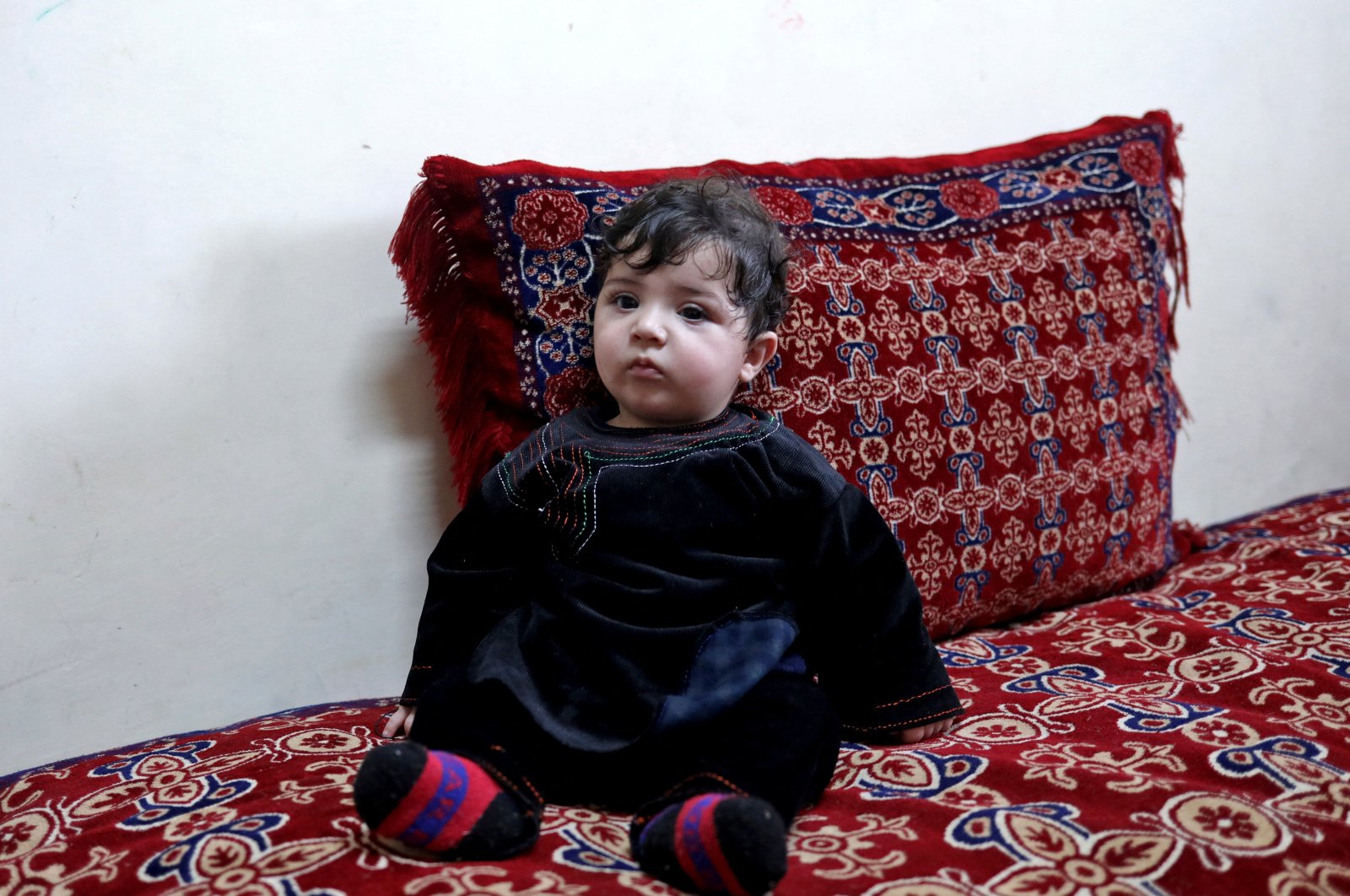 Baby Sohail Ahmadi sits inside the house of Hamid Safi, a taxi driver who had found Sohail in the airport, in Kabul, Afghanistan, Jan. 7, 2022. (Reuters Photo)