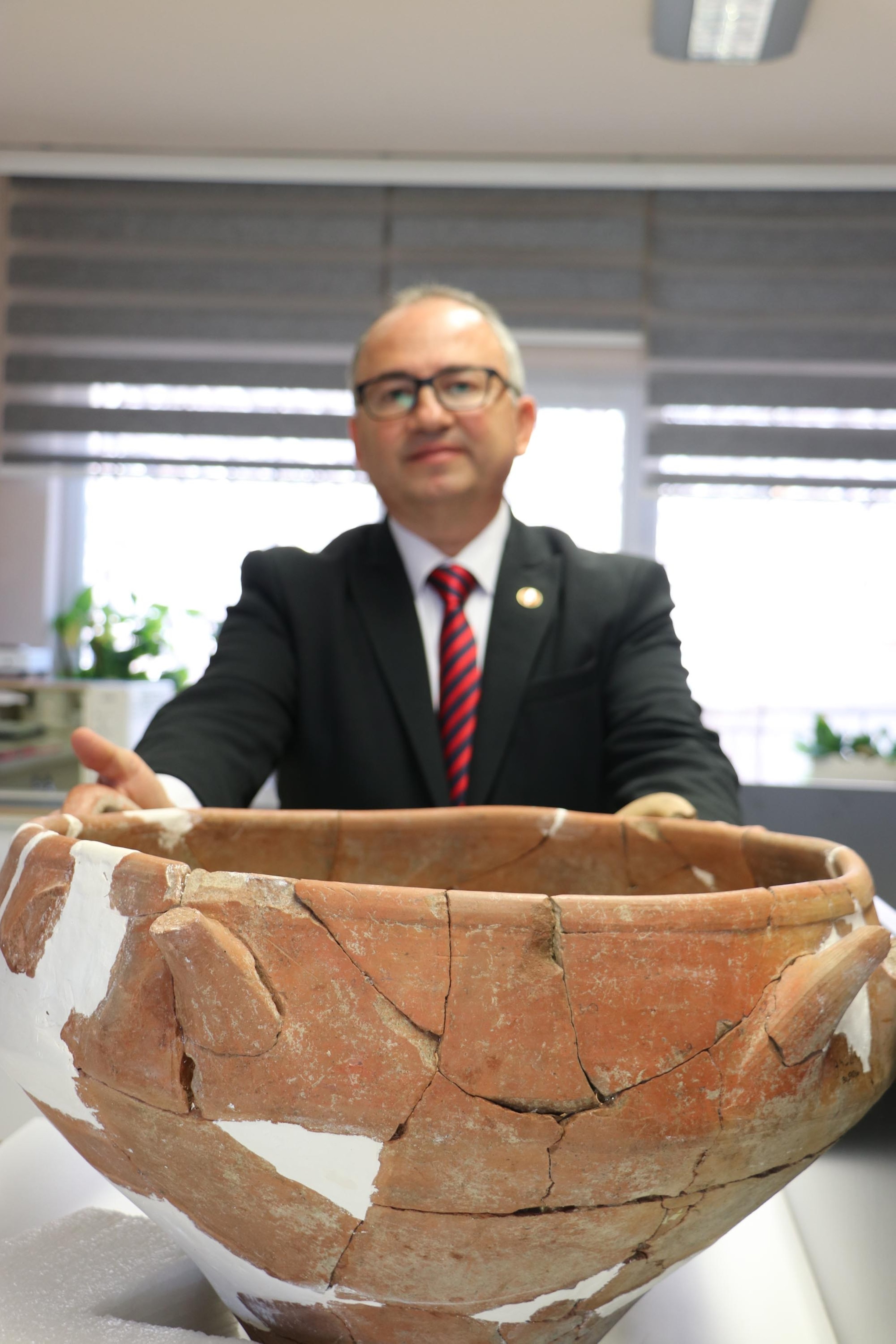 Director of the Ankara Regional Restoration and Conservation Laboratory, Cengiz Özduygulu, poses with a restored piece, Ankara, Turkey, January 9, 2022. (DHA Photo)