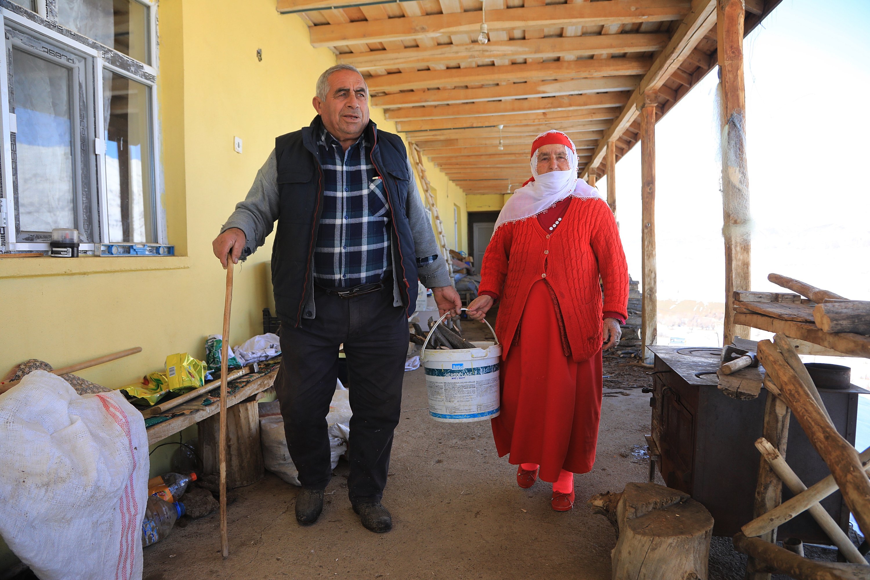 Wanita berbaju merah, Nafiye Caz, dan suaminya Hikmet Caz berpegangan tangan di balkon mereka, Bingöl, Turki, 10 Januari 2022. (AA Photo)