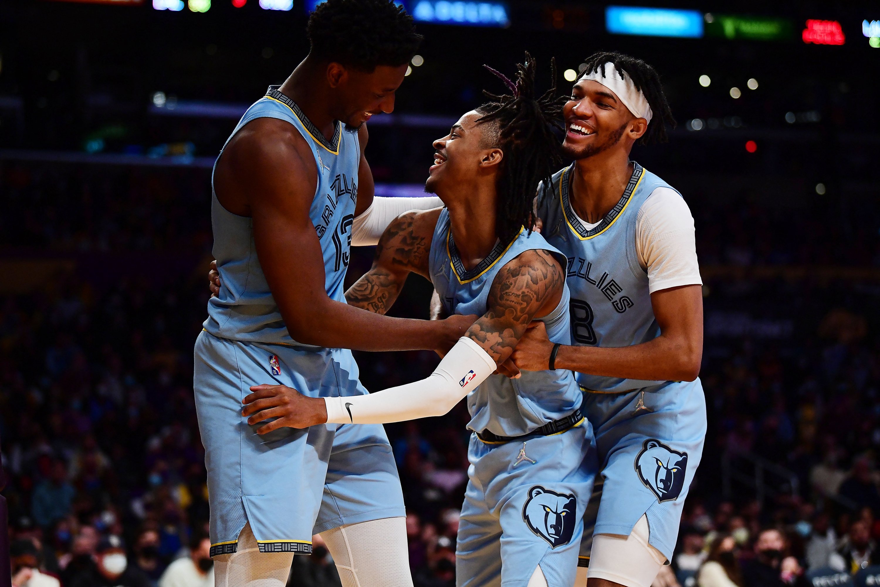 Guard Memphis Grizzlies Ja Morant (tengah) bereaksi dengan penyerang Jaren Jackson Jr. (kiri) dan guard Ziaire Williams (kanan) setelah mencetak gol dalam pertandingan NBA melawan Los Angeles Lakers, Los Angeles, AS, 9 Januari 2022. (Foto Reuters)