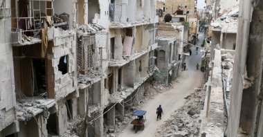 Residents walk near damaged buildings in the Old City of Aleppo, Syria, May 5, 2016. (Reuters Photo)
