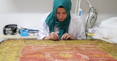 A restorer carefully works on an 18th-century flag from Amasya Museum, Ankara, Turkey, Jan. 9, 2022. (DHA Photo)