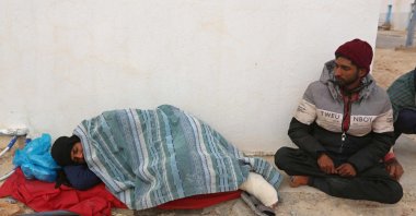Migrants rescued by Tunisia's national guard during an attempted crossing of the Mediterranean by boat, rest on the beach at the port of el-Ketef in Ben Guerdane in southern Tunisia near the border with Libya, on Jan. 6, 2022. (AFP)