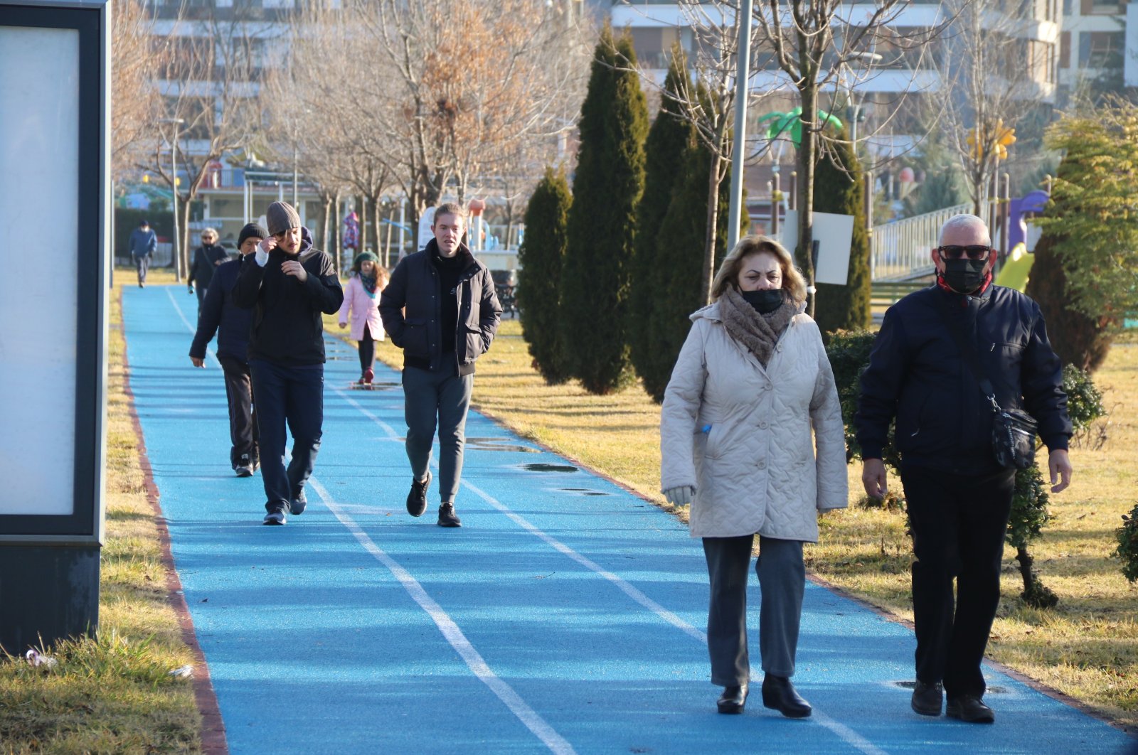 People with and without protective masks against COVID-19 walk in a park in Eskişehir, central Turkey, Jan. 9, 2022. (IHA Photo)