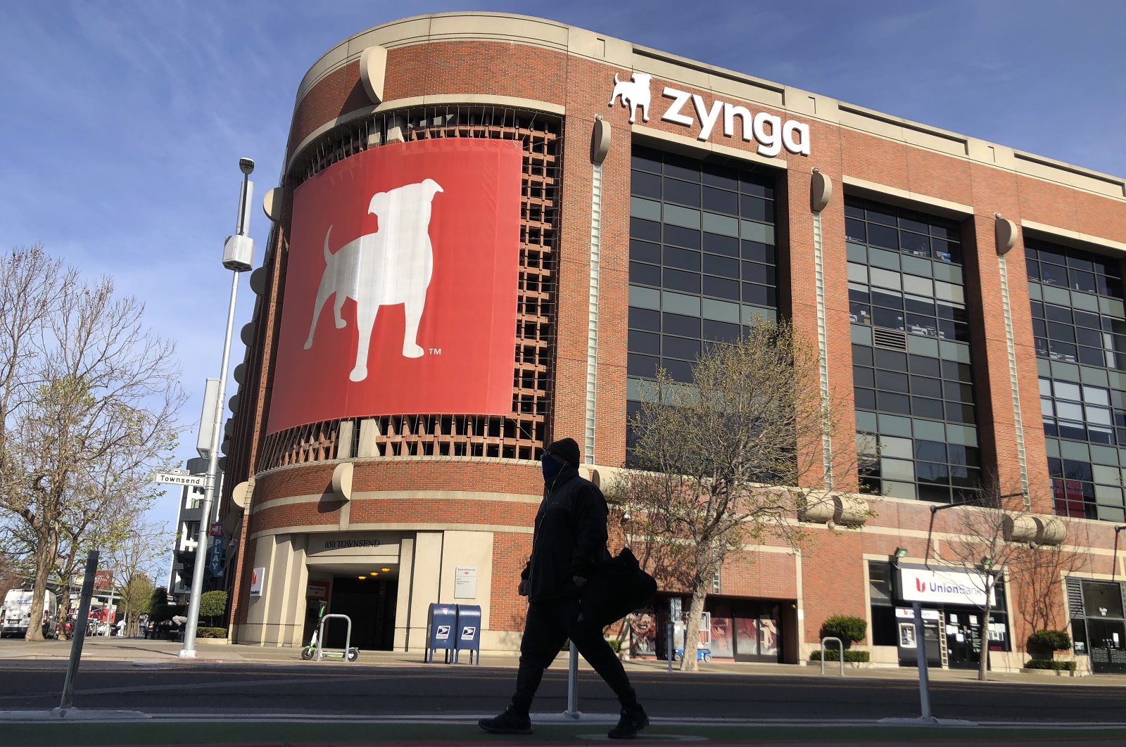 A pedestrian walks in front of a sign at Zynga in San Francisco, U.S., March 16, 2021. (AP Photo)