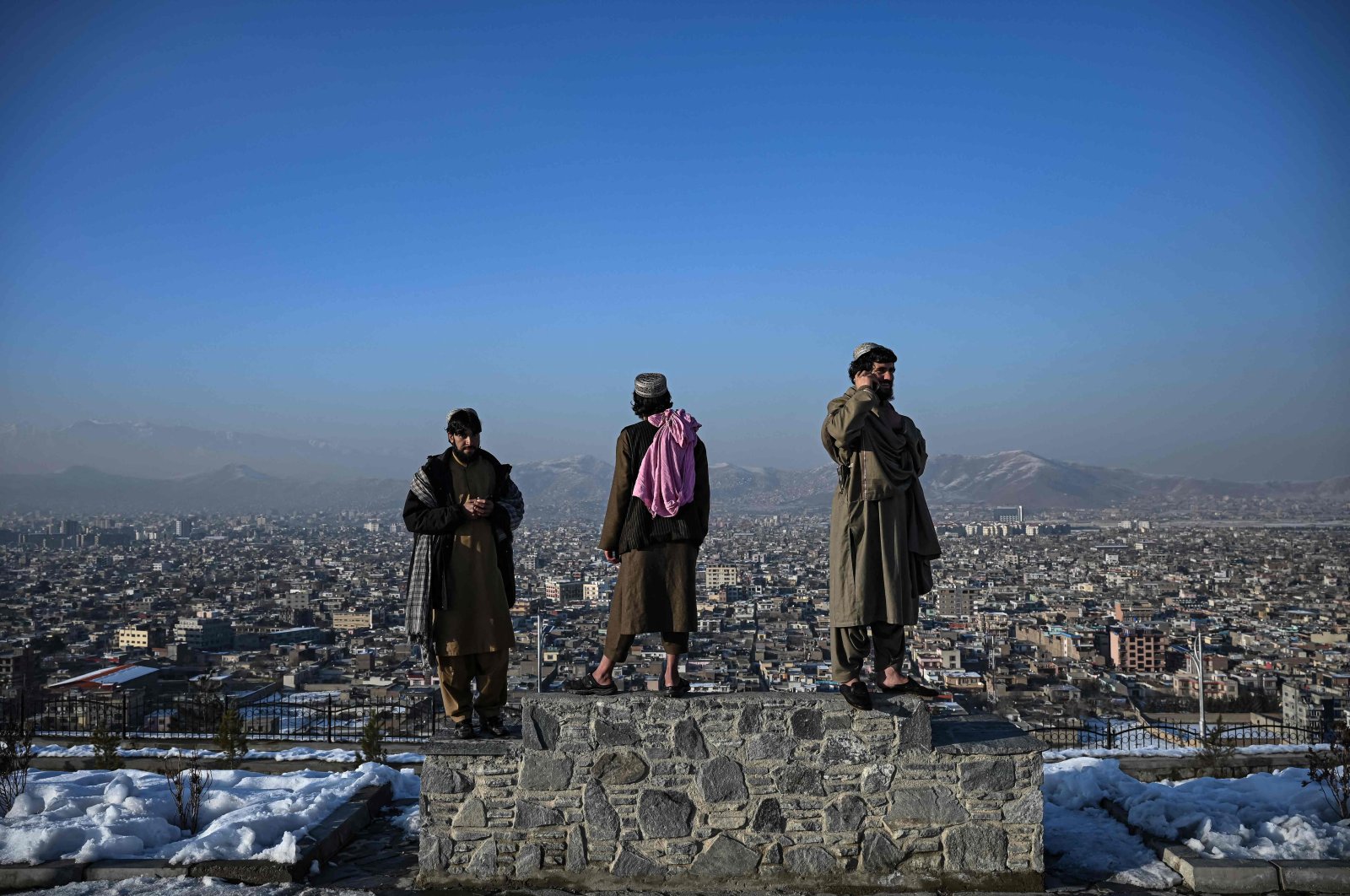 Members of the Taliban stand over a plinth overlooking Kabul city at the Wazir Akbar Khan hill in Kabul, Afghanistan, Jan. 10, 2022. (AFP)