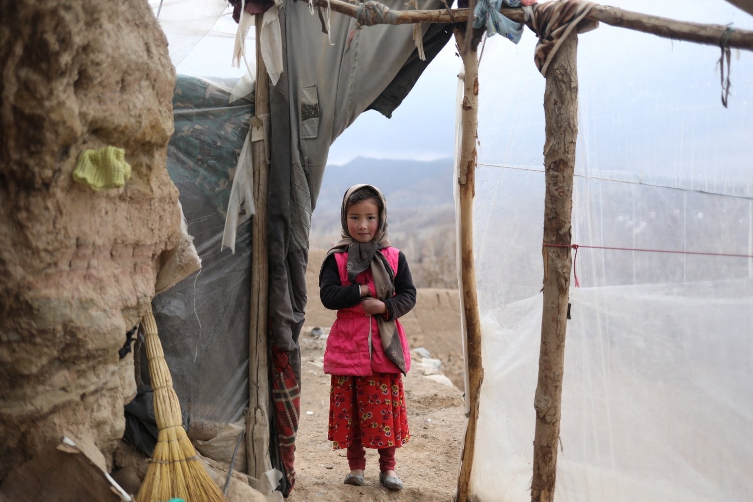 Mojgan, 9, poses for a photograph in the doorway of a house in Bamiyan, Afghanistan, Dec. 22, 2021. (Reuters Photo)