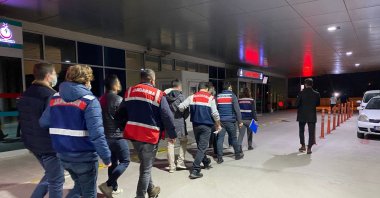 Gendarmerie officers escort detained suspects to a hospital for medical checks, in Izmir, western Turkey, Jan. 11, 2022. (IHA Photo)