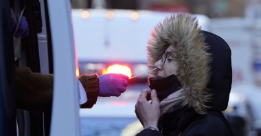 A woman wearing a winter coat gets tested for COVID-19 at a mobile testing site in New York, U.S., Jan. 11, 2022.  (AP Photo/Seth Wenig)