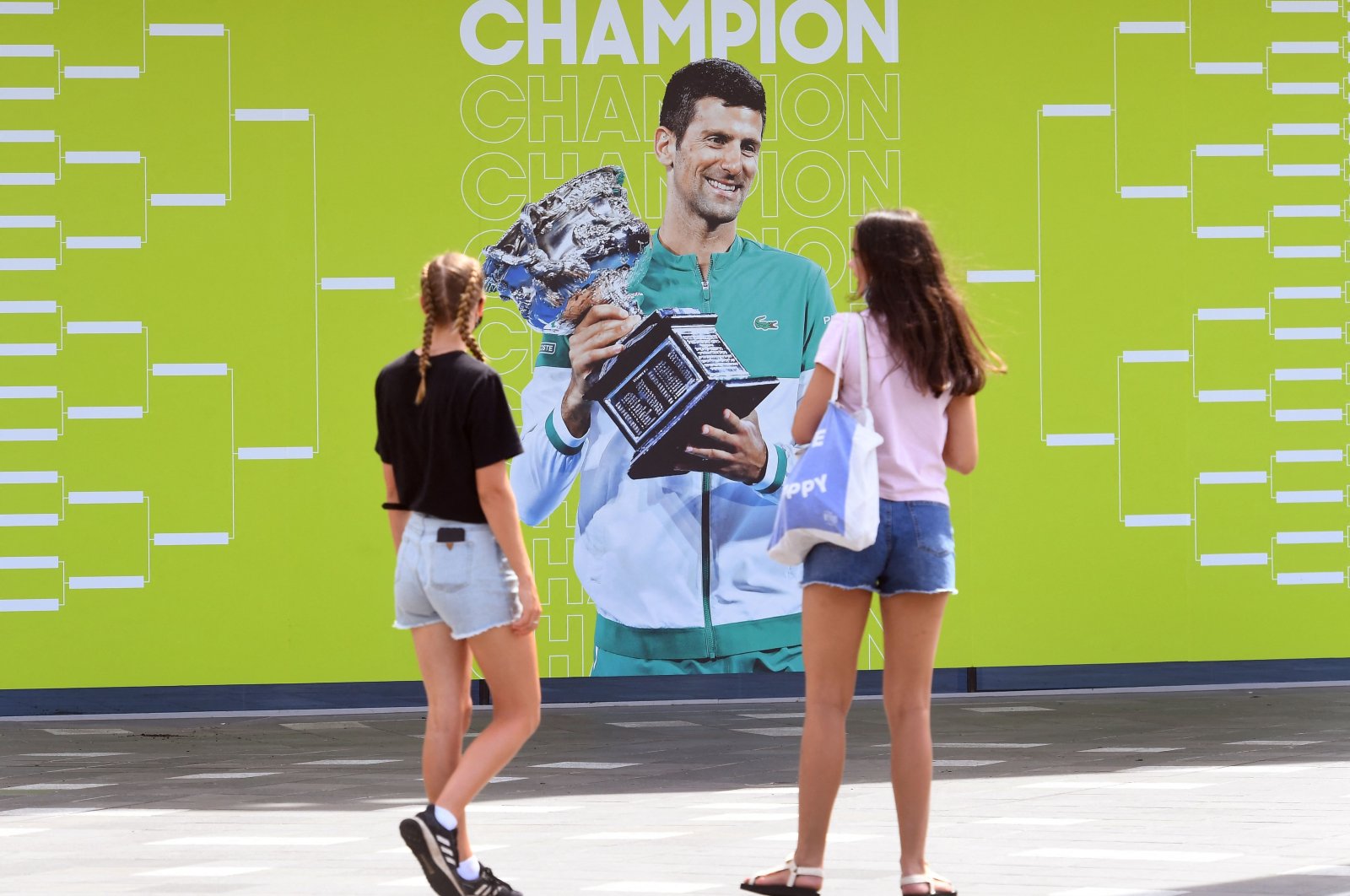 People look at an image of Serbia&#039;s Novak Djokovic ahead of the Australian Open, Melbourne, Australia, Jan. 11, 2022. (AFP Photo)
