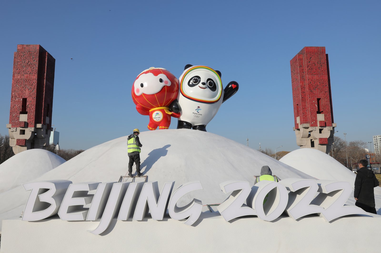 Chinese workers spray paint near the Bing Dwen Dwen, the Beijing 2022 Winter Olympic Mascot and Shuey Rhon Rhon, the 2022 Beijing Winter Paralympic Games Mascot, in Beijing, China, Jan. 11, 2022. (EPA Photo)