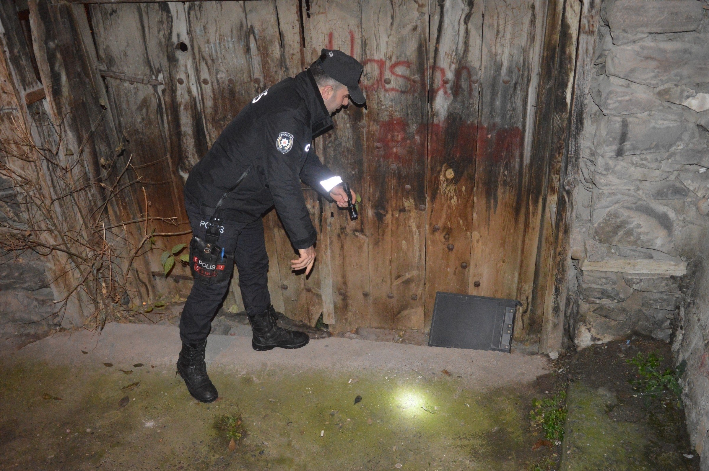 The empty safe discarded by the suspect is inspected by a police officer, Tokat province, northern Turkey, Dec. 11, 2022. (IHA Photo).