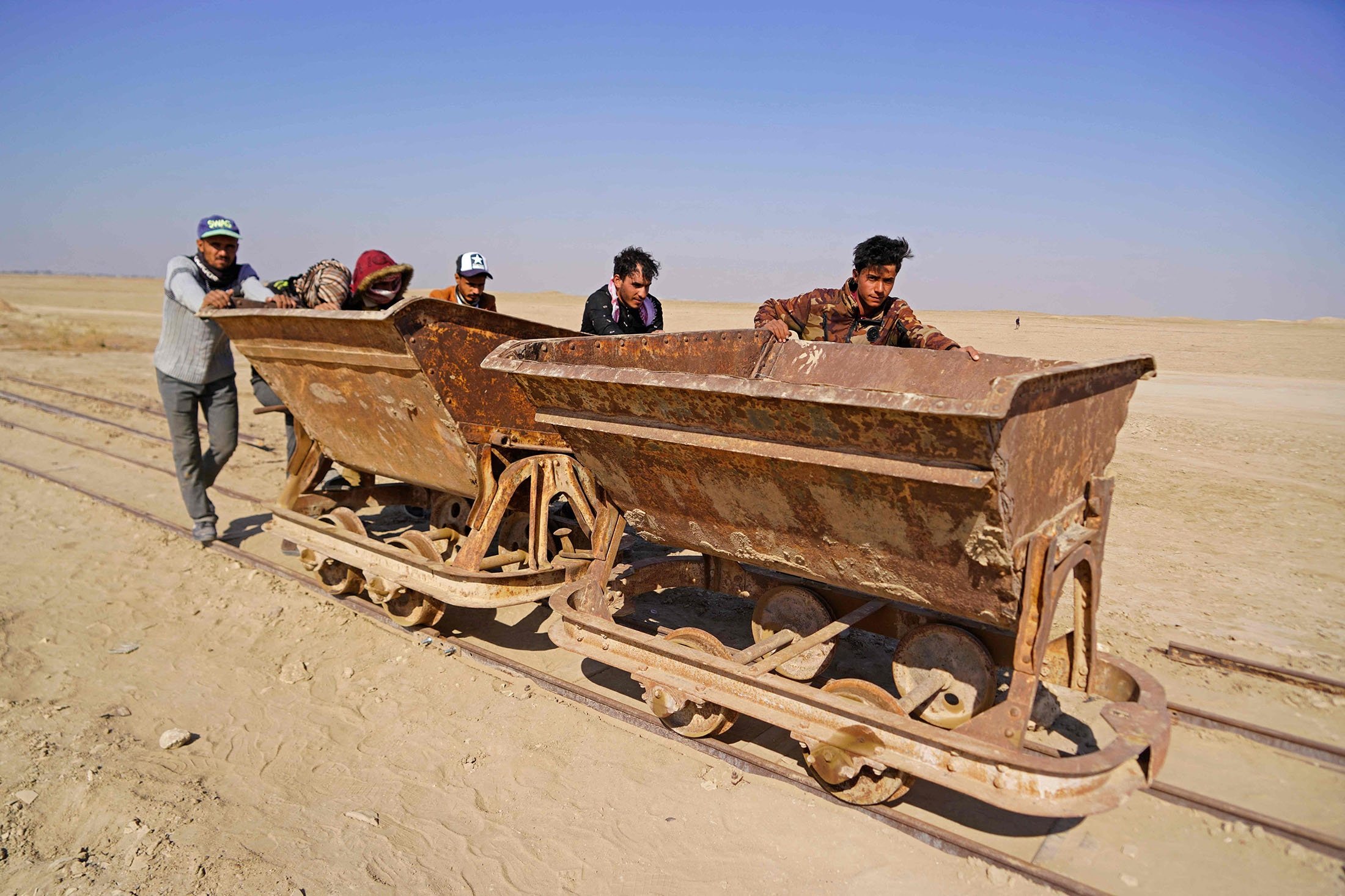 Workers use an old rail cart to transport material as they take part in a German-Iraqi archaeological expedition to restore the white temple of Anu in the Warka (ancient Uruk) site in Muthanna province, Iraq, Nov. 27, 2021. (AFP Photo)