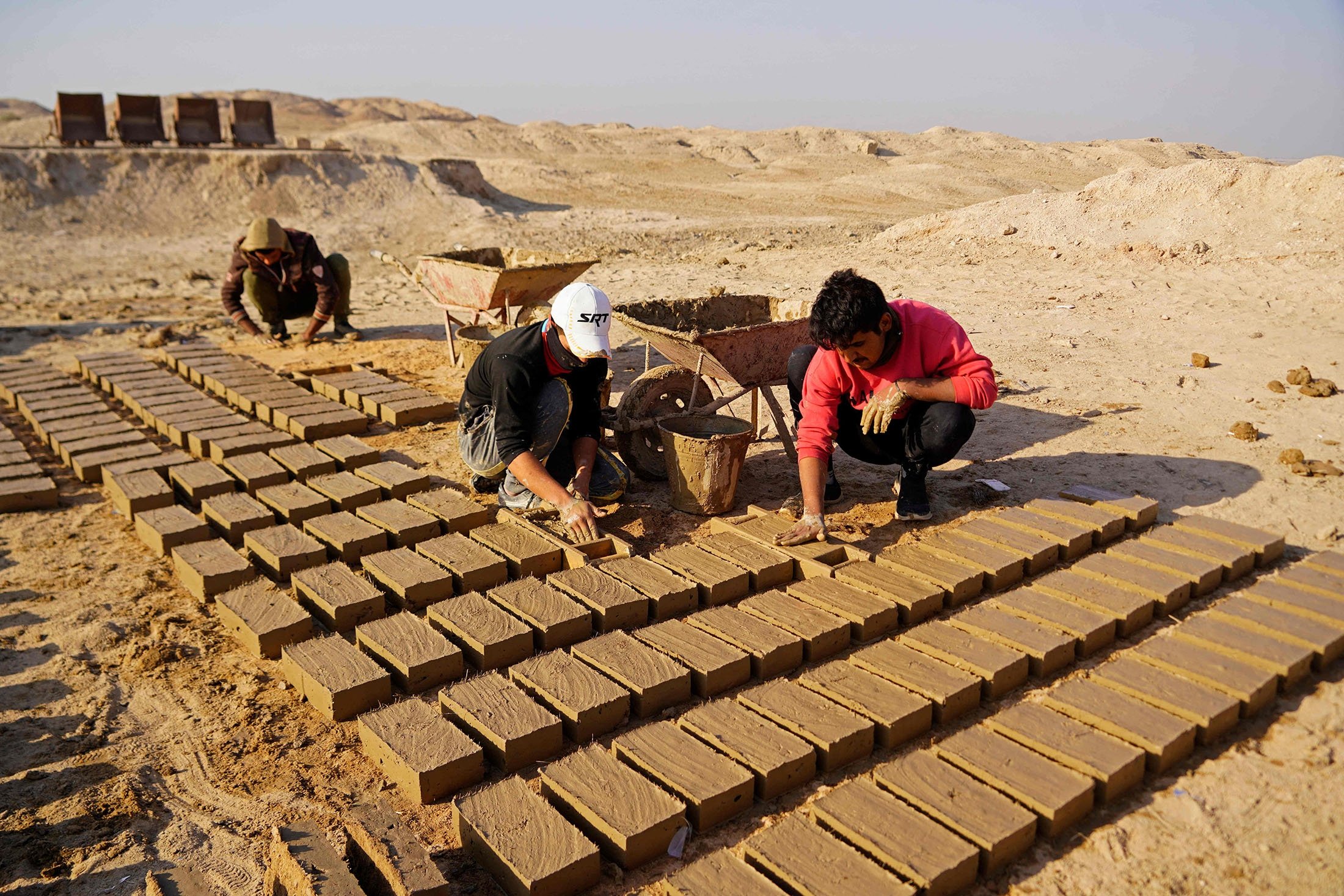 Workers make traditional clay bricks as they take part in a German-Iraqi archaeological expedition to restore the white temple of Anu in the Warka (ancient Uruk) site in Muthanna province, Iraq, Nov. 27, 2021. (AFP Photo)