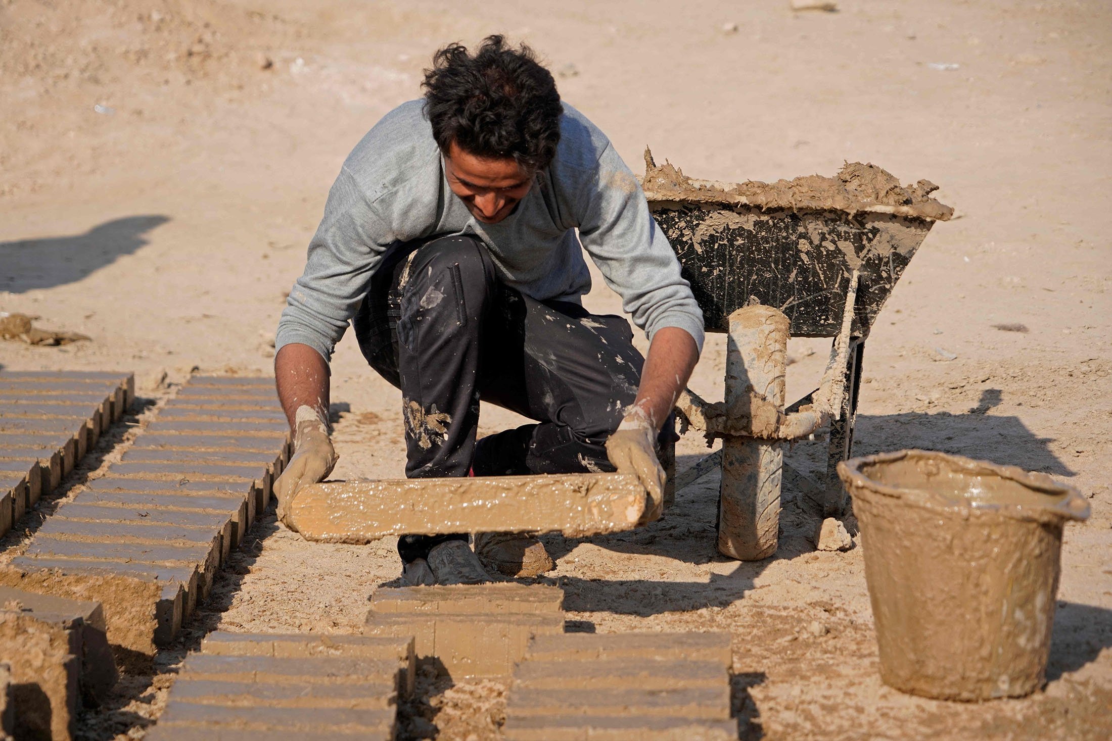 A worker makes traditional clay bricks during a German-Iraqi archaeological expedition to restore the white temple of Anu in the Warka (ancient Uruk) site in Muthanna province, Iraq, Nov. 27, 2021. (AFP Photo)